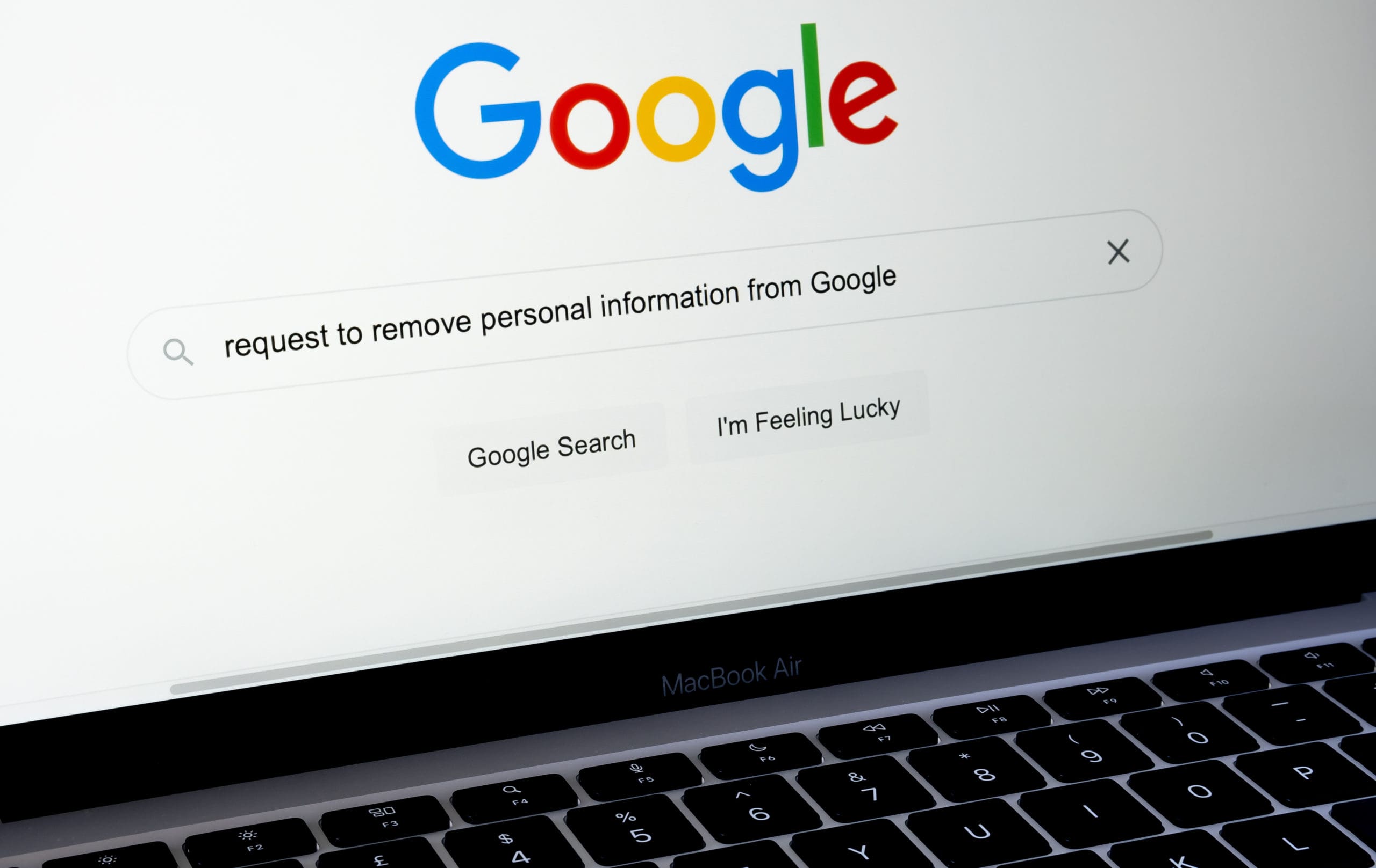 A google search bar is displayed on a laptop computer.