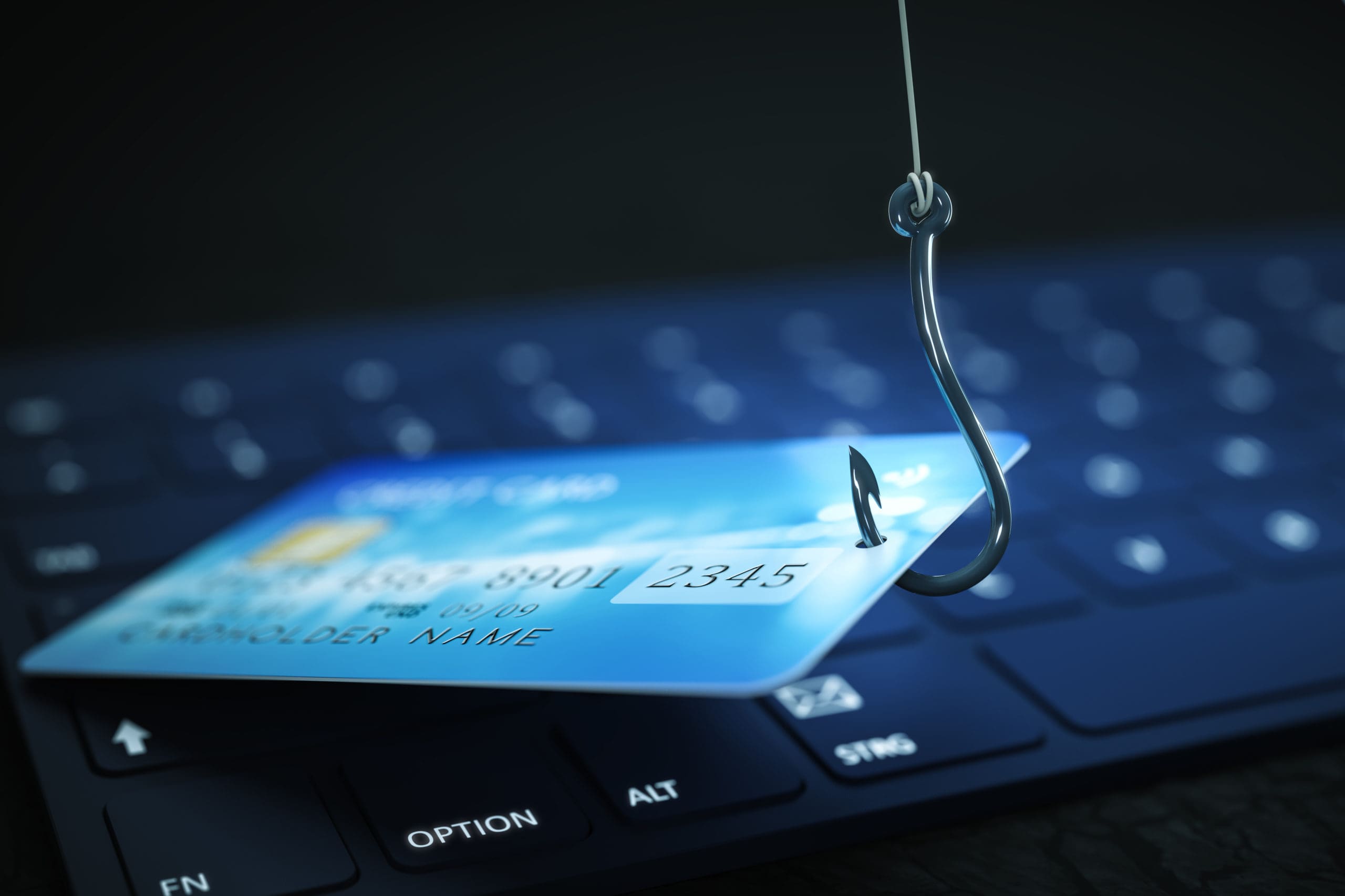 A credit card with a hook attached to it on a keyboard.