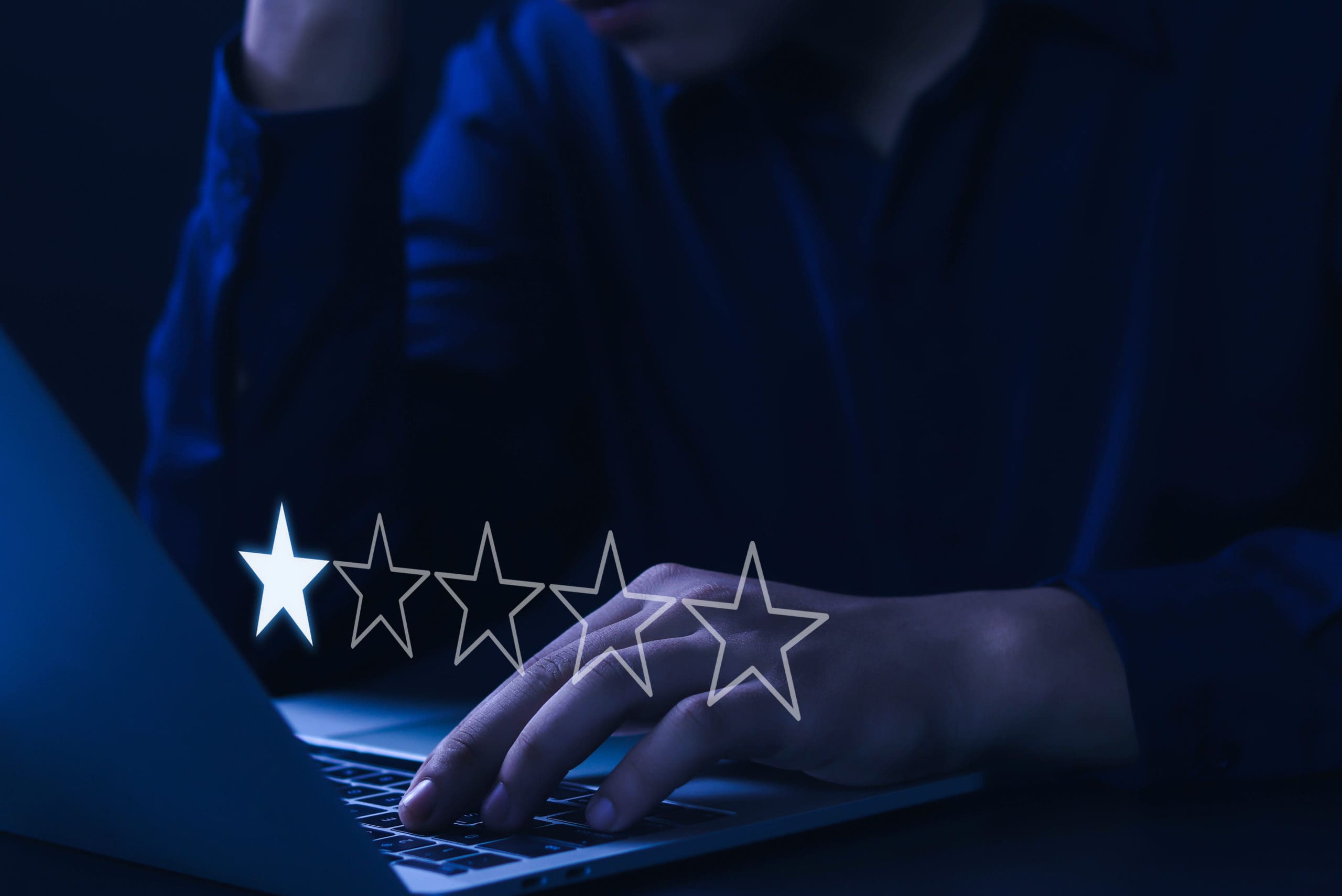 A man typing on a laptop with stars on it.